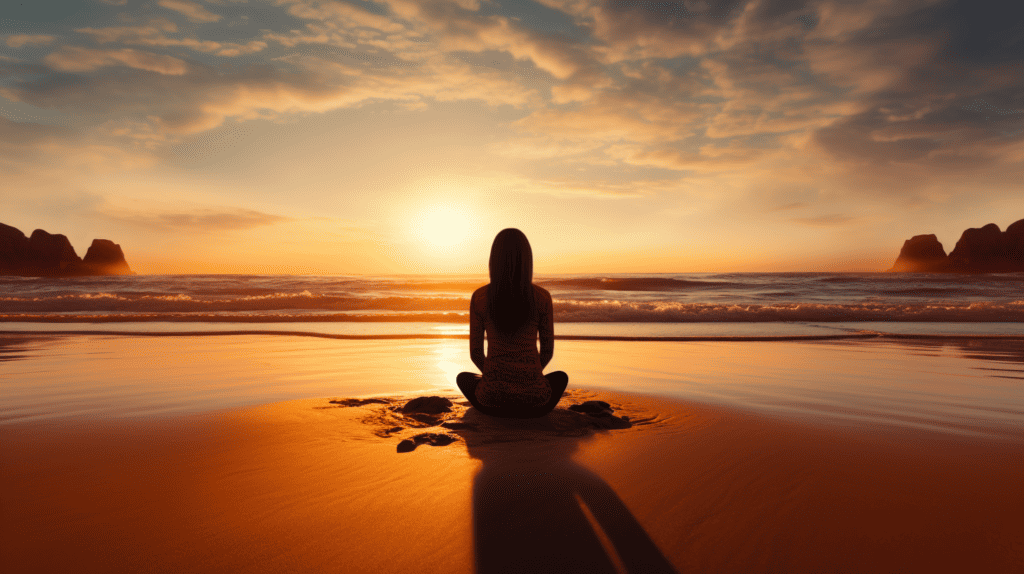 Person sitting in the sand at a beach, meditating.